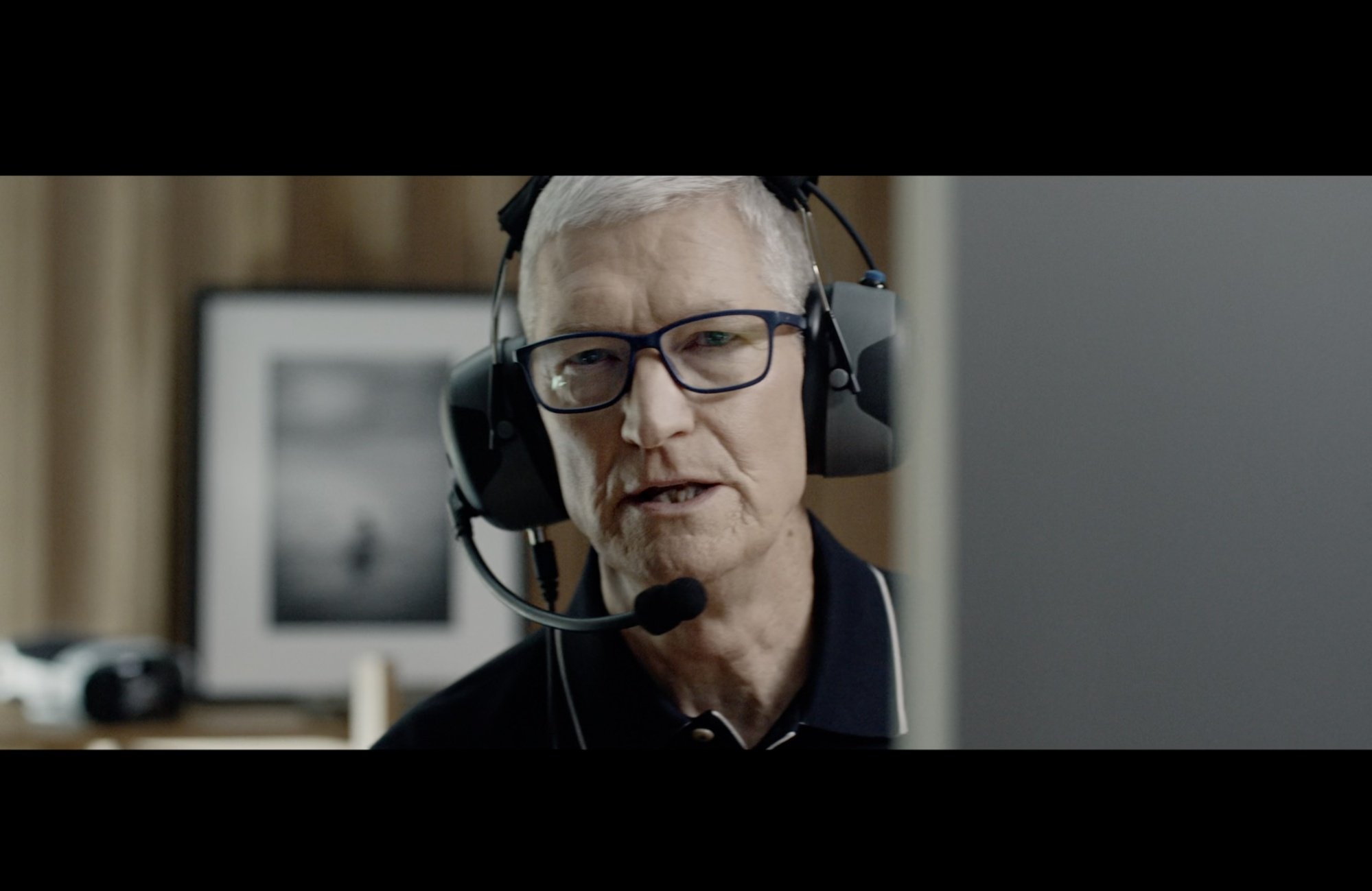 Tim Cook with a headset behind a computer